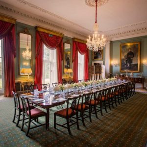 Full-room image of State Dining Room with dining table at full length, dressed with cutlery, crystal and crockery